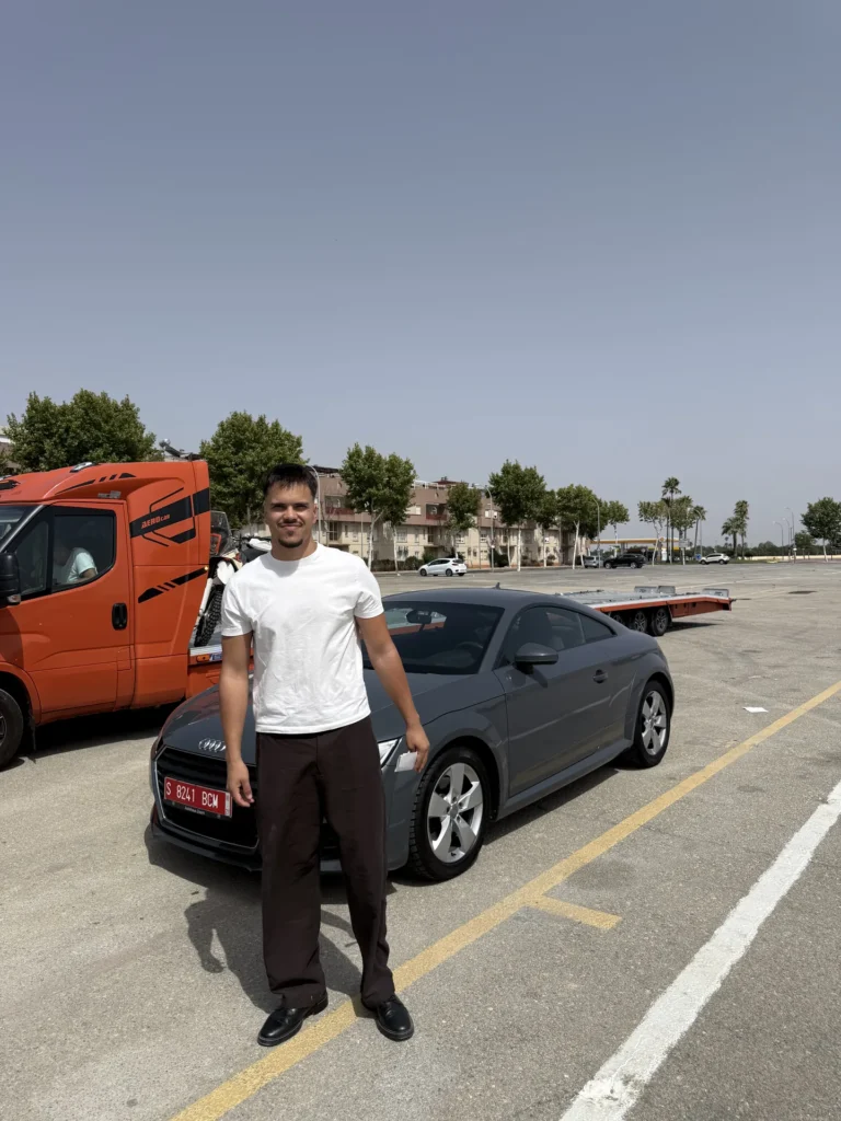 David Vega, fundador de Votton.es, junto a un Audi TT gris y el camión portacoches
