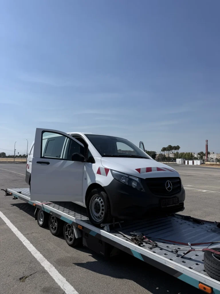 Furgoneta Mercedes-Benz Vito blanca cargada sobre un remolque portacoches